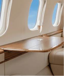 Private jet cabin interior with a glass of champagne on a wood table