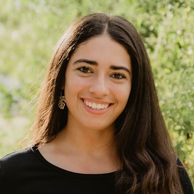 Portrait of a smiling woman with long dark hair outdoors