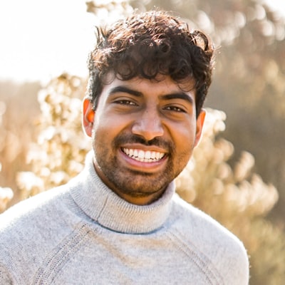 Portrait of a smiling man in a grey turtleneck outdoors