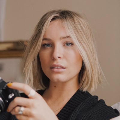 Portrait of a blonde woman holding a camera