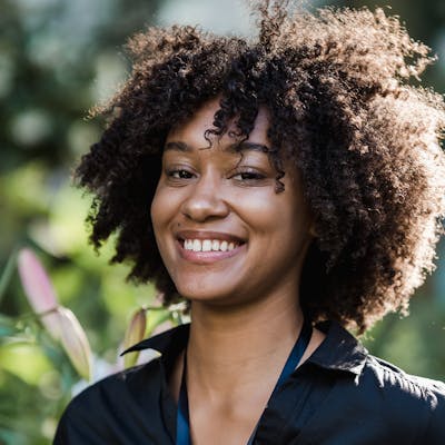 Portrait of a smiling woman with curly hair outdoors
